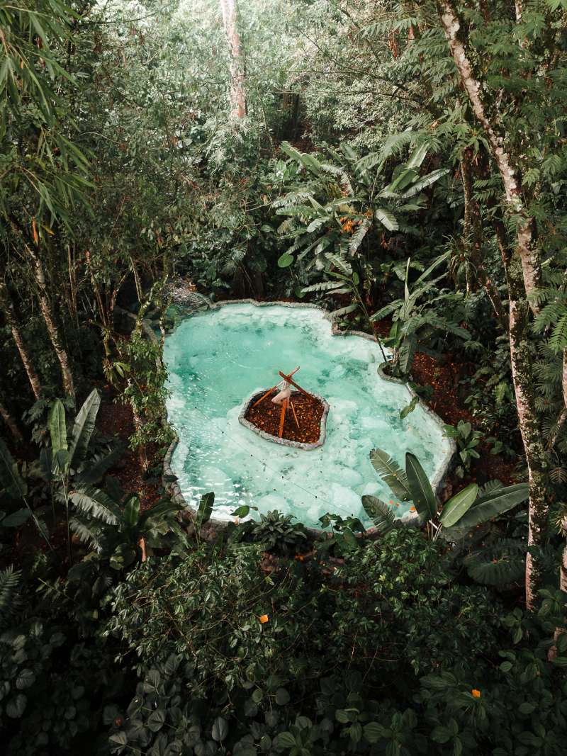 Laguna natural rodeada de selva tropical vista desde arriba, ideal para un wellness retreat cerca de Medellín en Cerro Tusa Springs